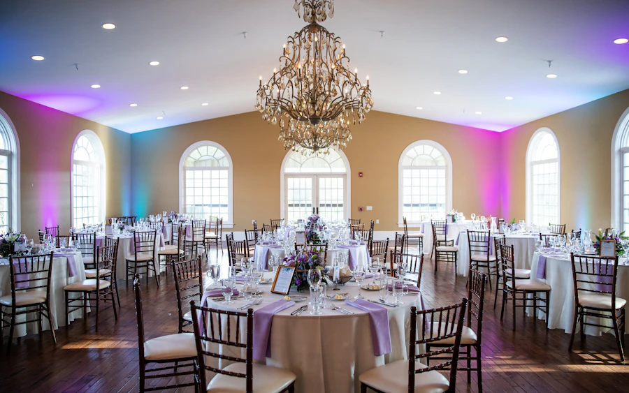 An event room set with tables and a chandelier